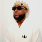 Afrobeats star Davido poses in a white outfit, wearing a jeweled crown and black sunglasses during the promotion of his sixth studio album, ORIADÉ.