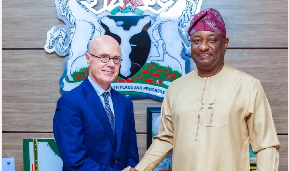 Nigerian Minister of Aviation Festus Keyamo wearing traditional attire shaking hands with a foreign official in front of the Nigerian Coat of Arms.