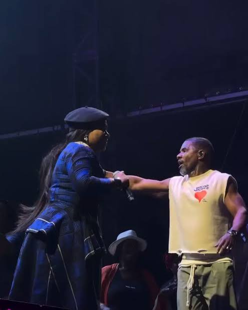 A live concert photo showing two Mercy Chinwo and gospel artist Kirk Franklin, performing 