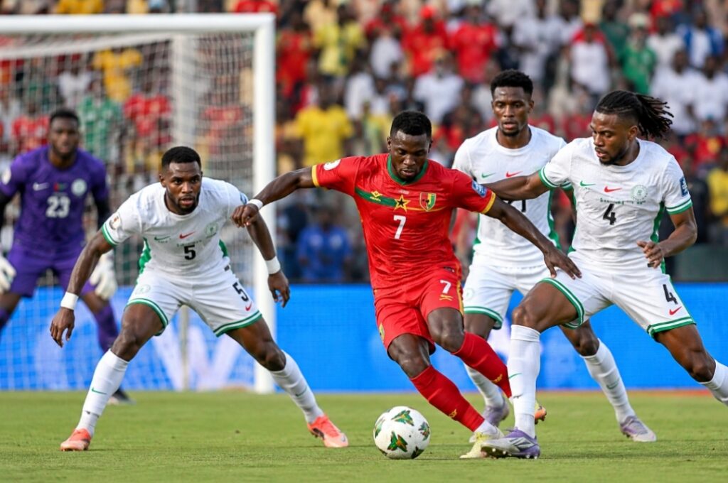 Guinea-Bissau player battles Nigeria’s Super Eagles defenders for the ball during an international football match.